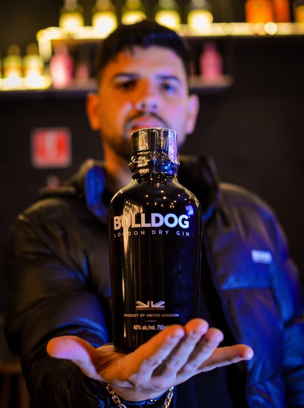 Garrafa de gin em destaque na estante de bebidas do Quintal da Villa